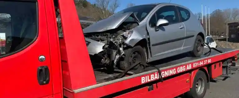 Avställd bil lastas på bärgningsbil för transport till bilskrot.